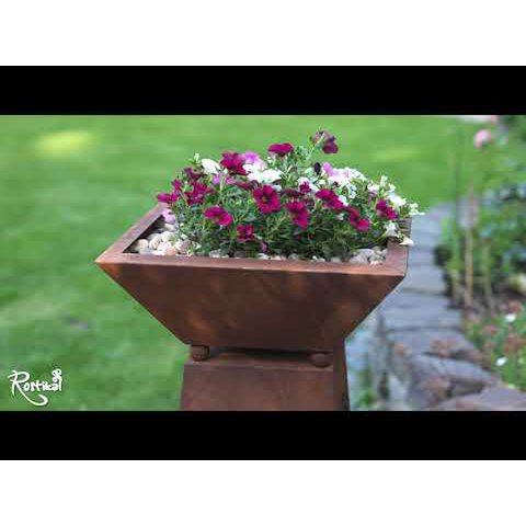 Roest metalen sierzuil met paardenbloemen en plantenbak